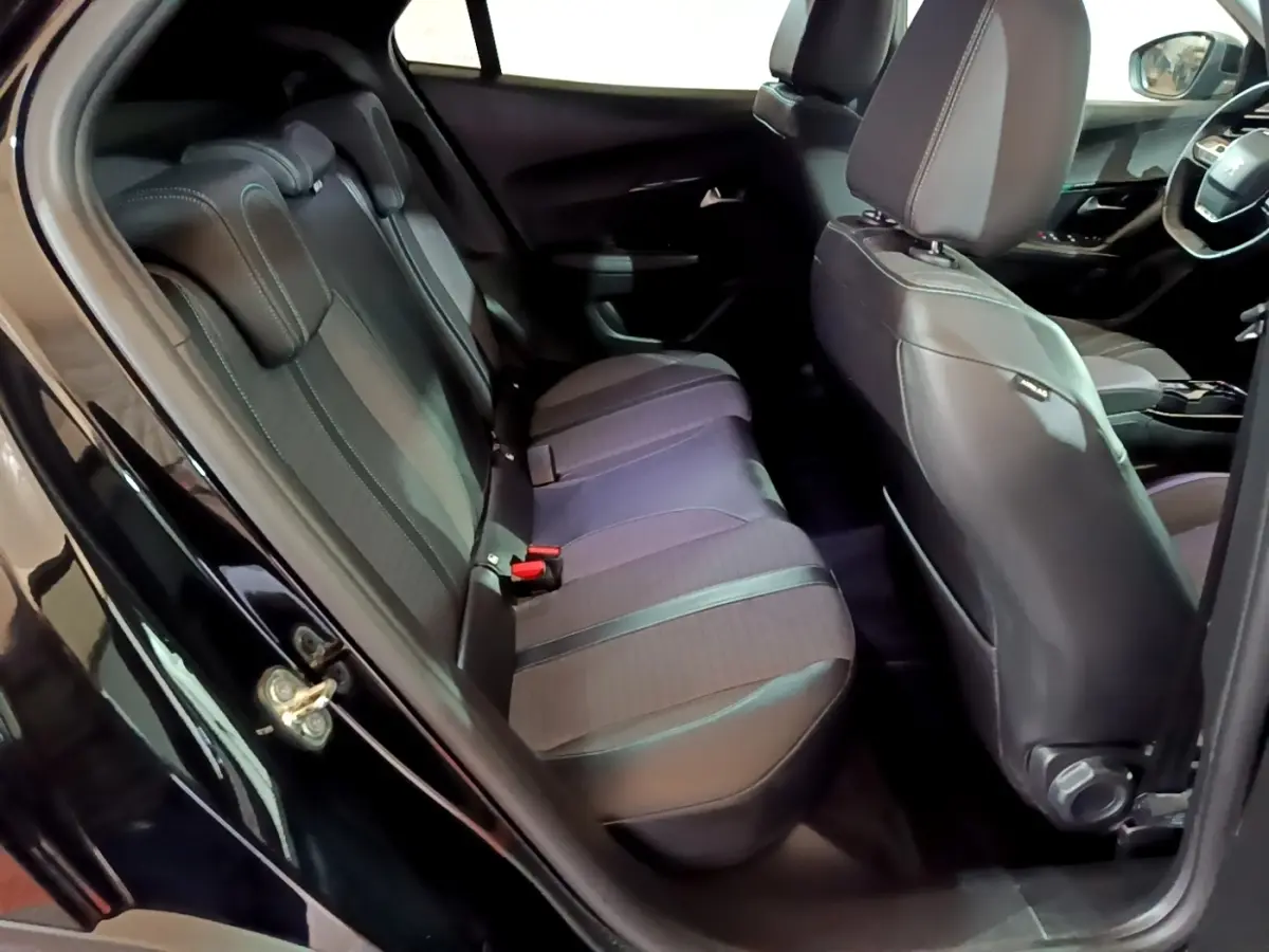 Vue intérieure côté gauche montrant la banquette arrière et les sièges avant noirs du Peugeot 2008 2021.