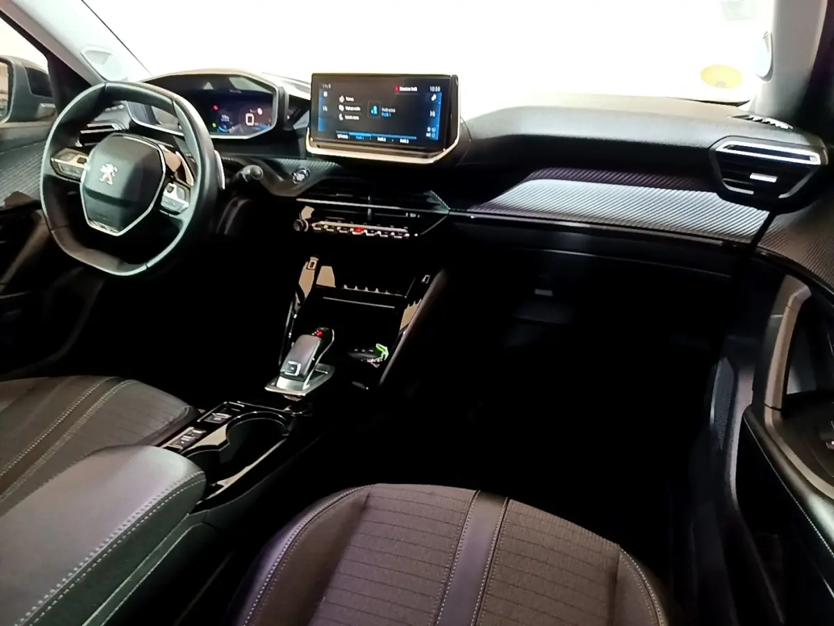 Vue intérieure avant du Peugeot 2008 noir 2021, avec tableau de bord digital et écran tactile central lumineux.