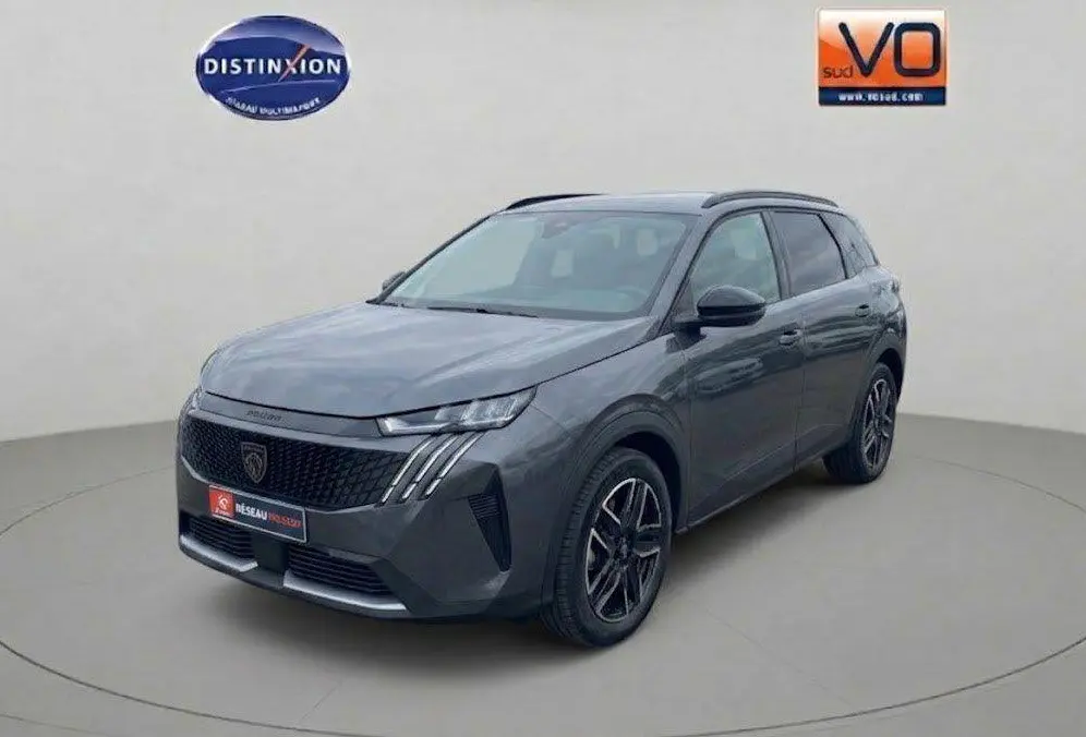 Peugeot 5008 Hybrid gris en vue 3/4 avant droit, avec calandre noire et feux LED distinctifs.