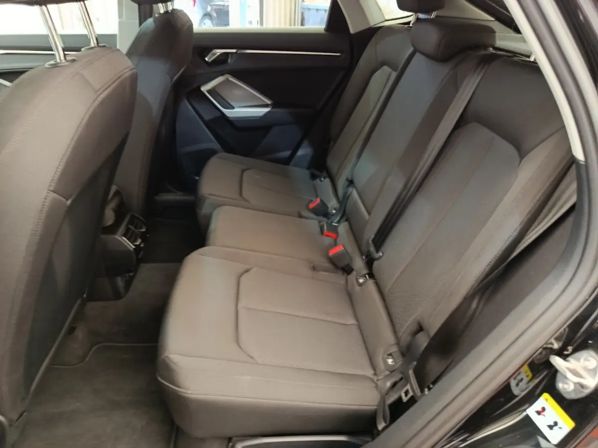 Vue intérieure côté droit sur la banquette arrière noire de l'Audi Q3 Sportback 35 TDI 150 Business Line 2023.