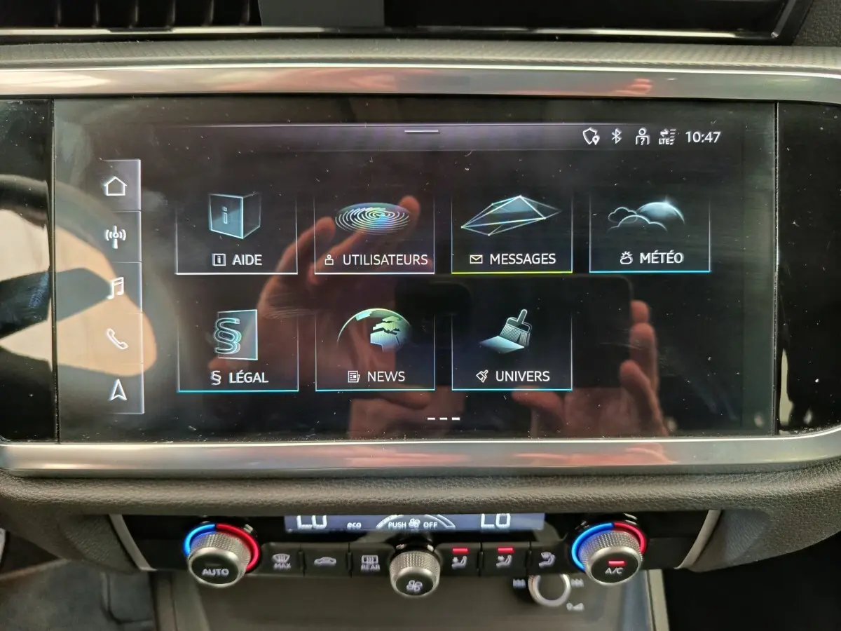 Écran tactile central de l'Audi Q3 Sportback 35 TDI 150 Business Line, affichage des menus, intérieur noir.