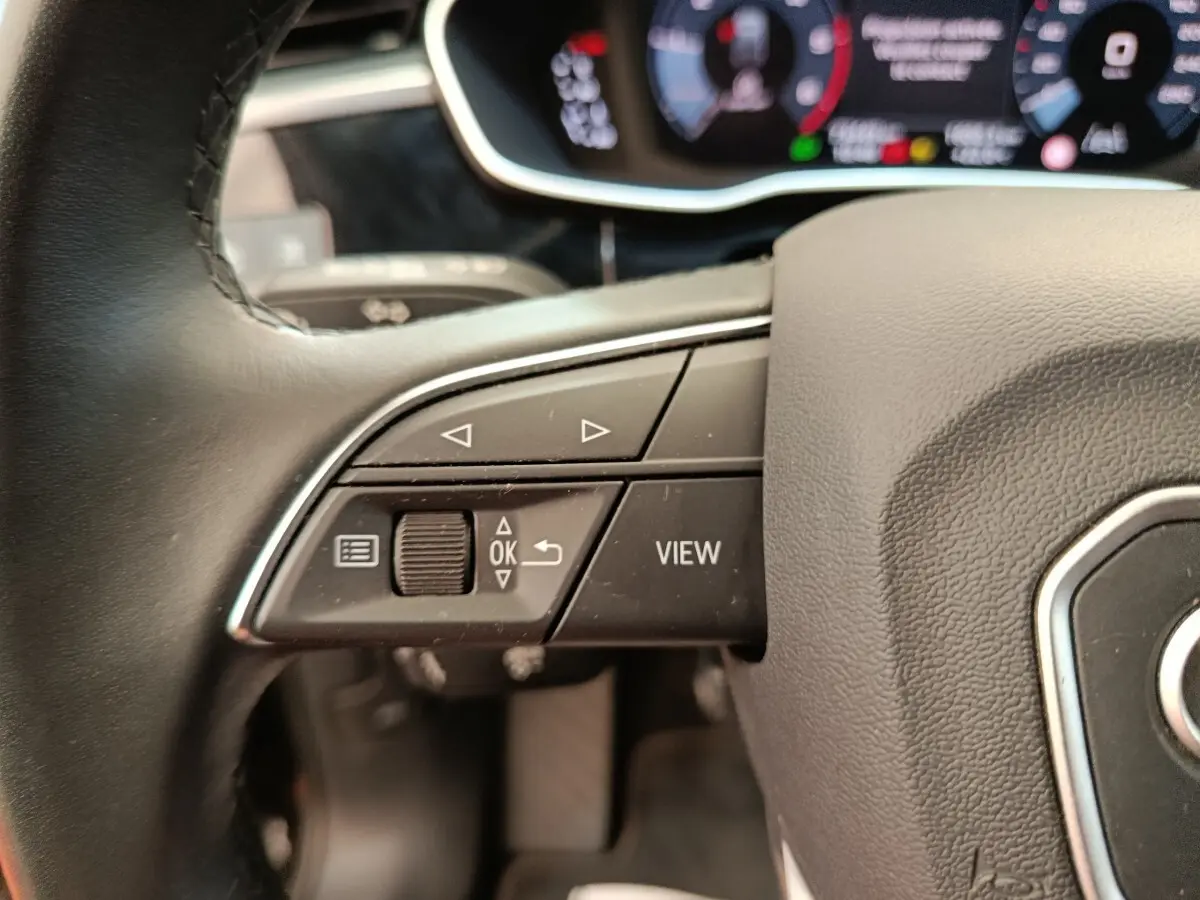 Gros plan sur le volant cuir noir multifonctions de l'Audi Q3 Sportback 35 TDI 2023 avec commandes intégrées.