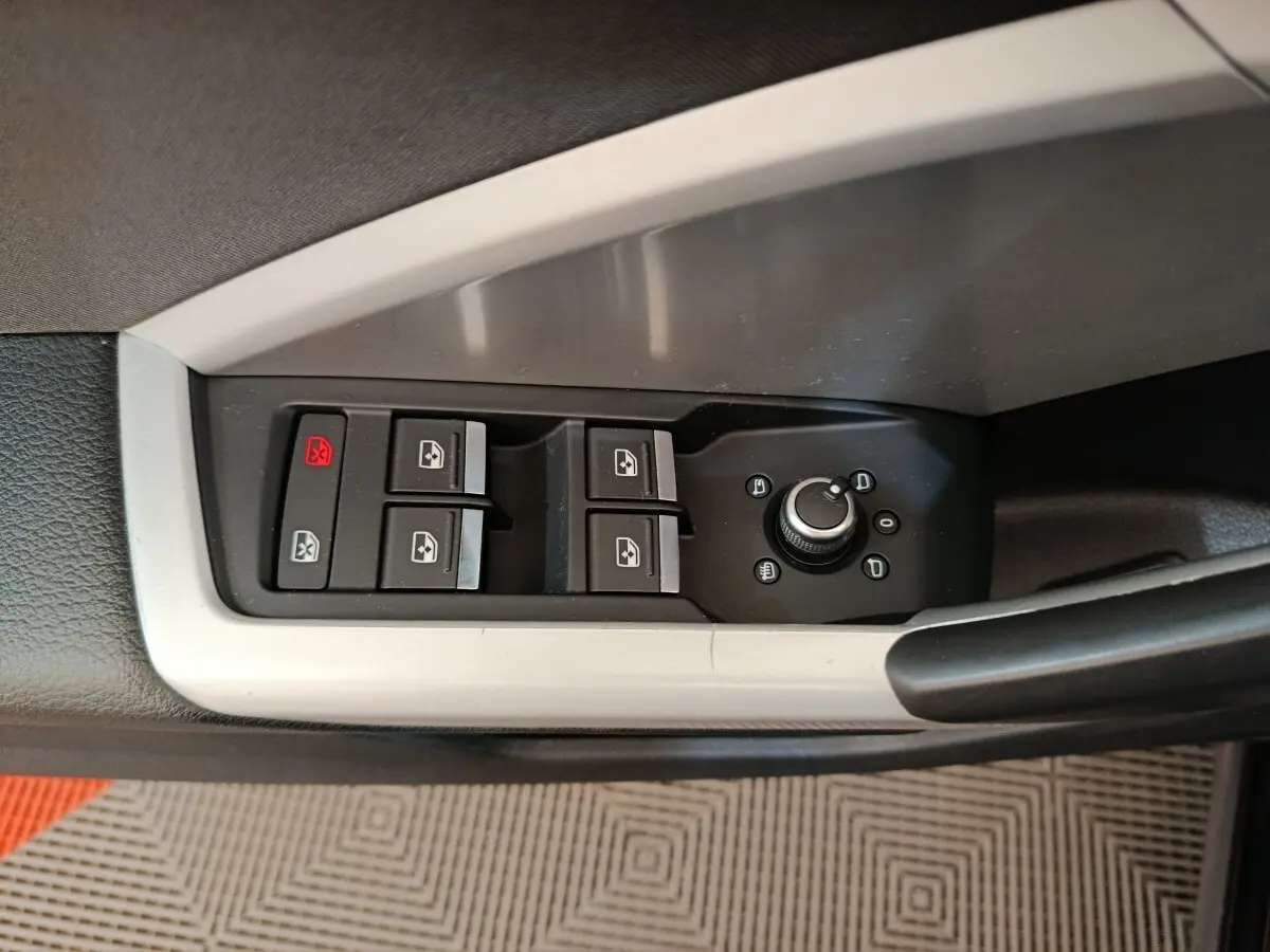 Vue rapprochée du panneau de commandes des vitres et rétroviseurs côté conducteur de l'Audi Q3 Sportback noir 2023.
