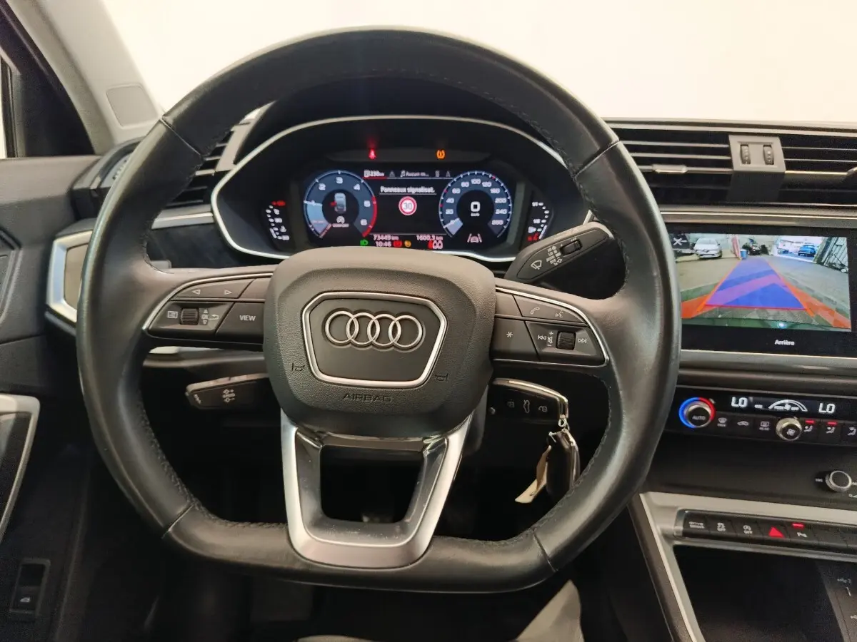 Vue intérieure centrée sur le volant cuir multifonctions d’un Audi Q3 Sportback 35 TDI 150 Business Line 2023.