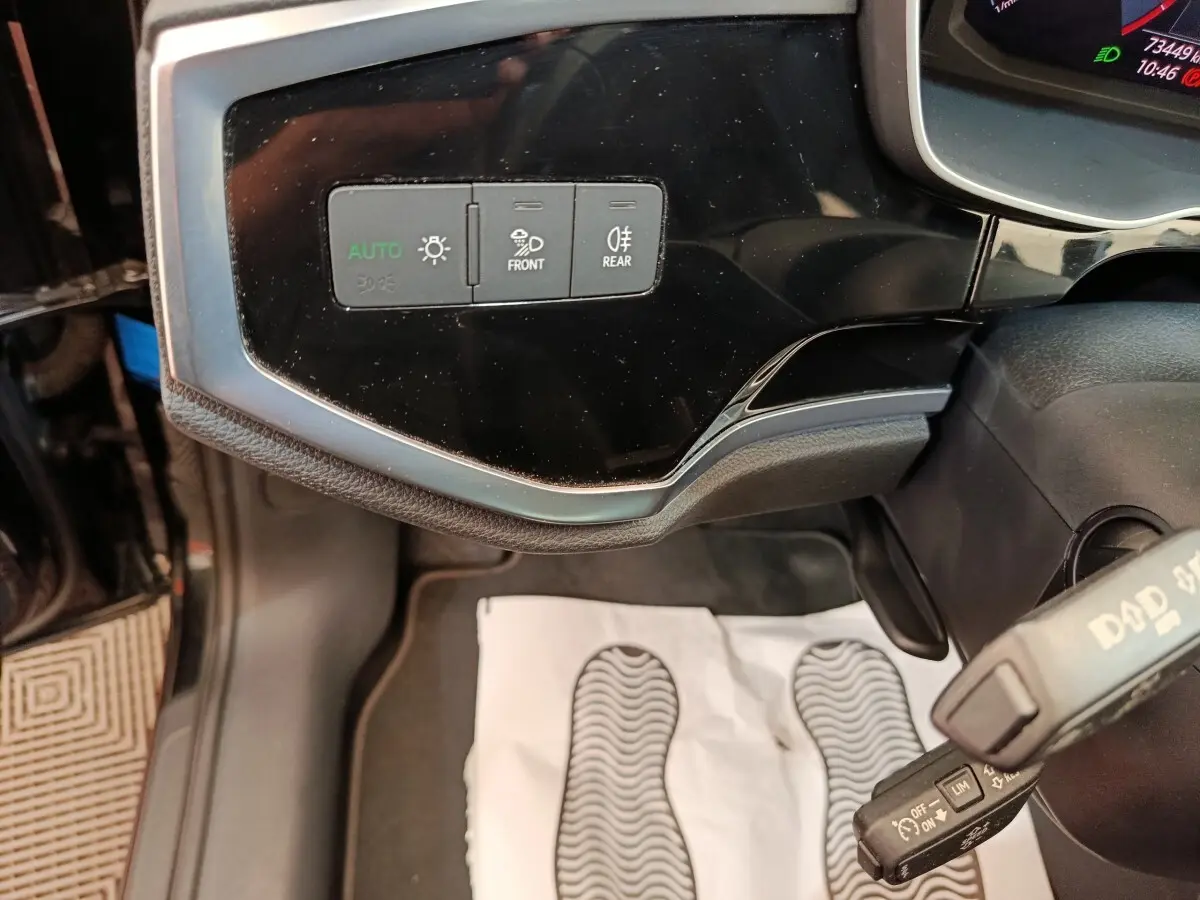 Détail du tableau de bord noir de l'Audi Q3 Sportback 35 TDI 150 Business Line, avec commandes d'éclairage et volant partiel.