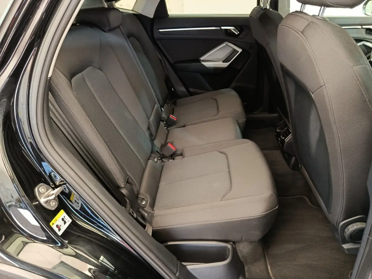 Vue intérieure côté gauche des sièges arrière noirs de l'Audi Q3 Sportback 35 TDI 150 Business Line 2023.