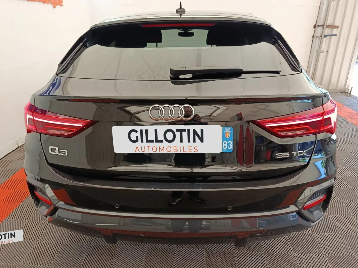 Vue arrière d'un Audi Q3 Sportback noir 35 TDI avec feux LED et logo Audi bien visibles.