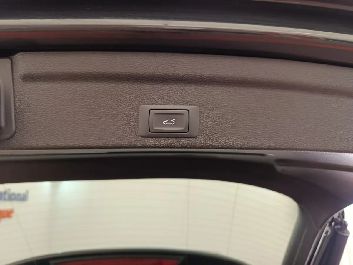 Bouton d'ouverture électrique du coffre sur la partie intérieure du hayon d'un Audi Q3 Sportback noir 2023.