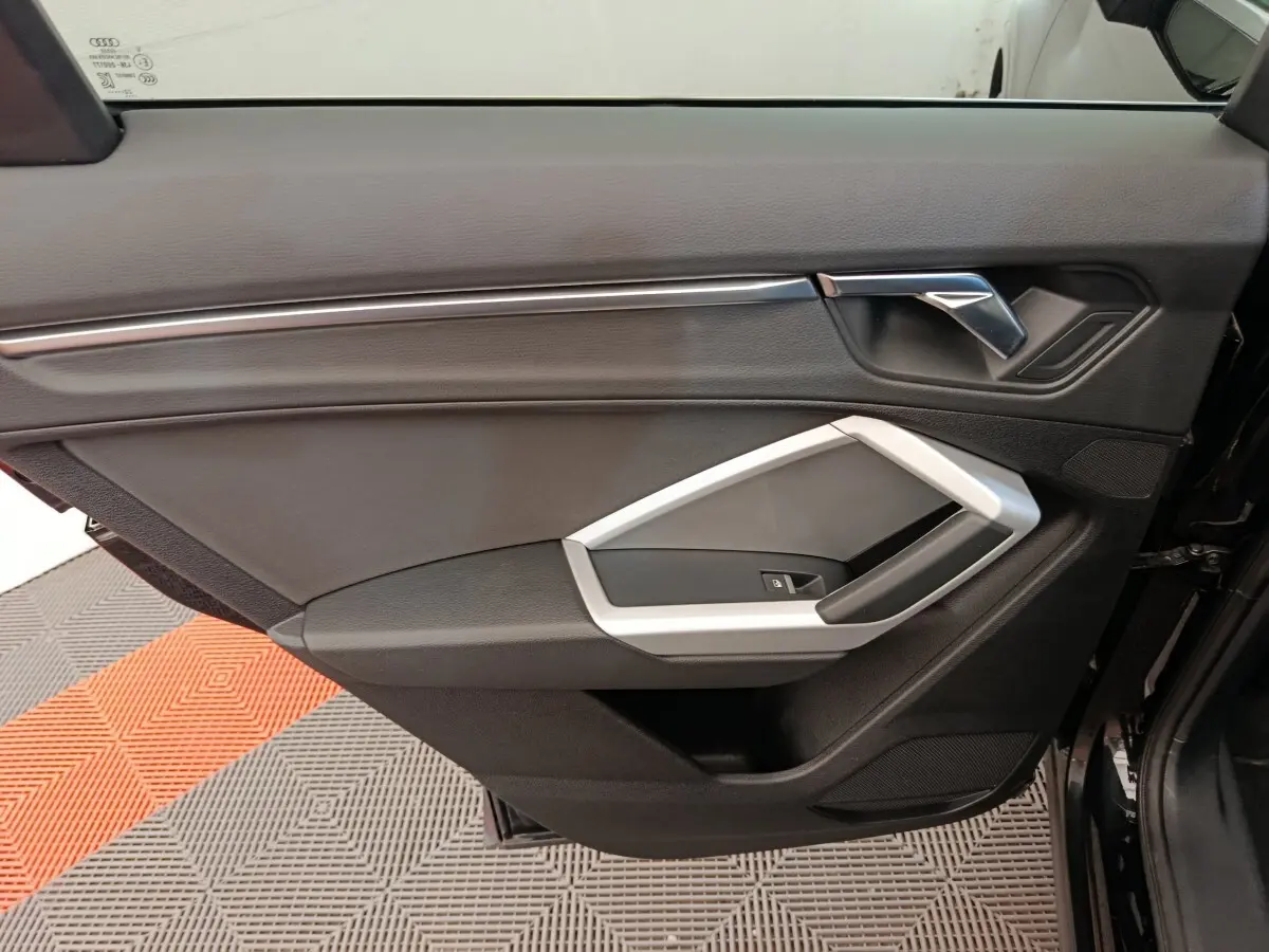 Vue rapprochée de la porte intérieure côté gauche noire de l'Audi Q3 Sportback 35 TDI 150 Business Line 2023.