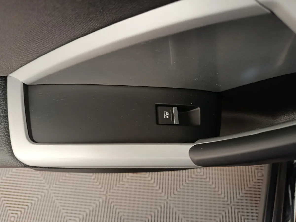 Gros plan sur le bouton de verrouillage centralisé noir et argenté, situé sur la porte intérieure d’un Audi Q3 Sportback noir.
