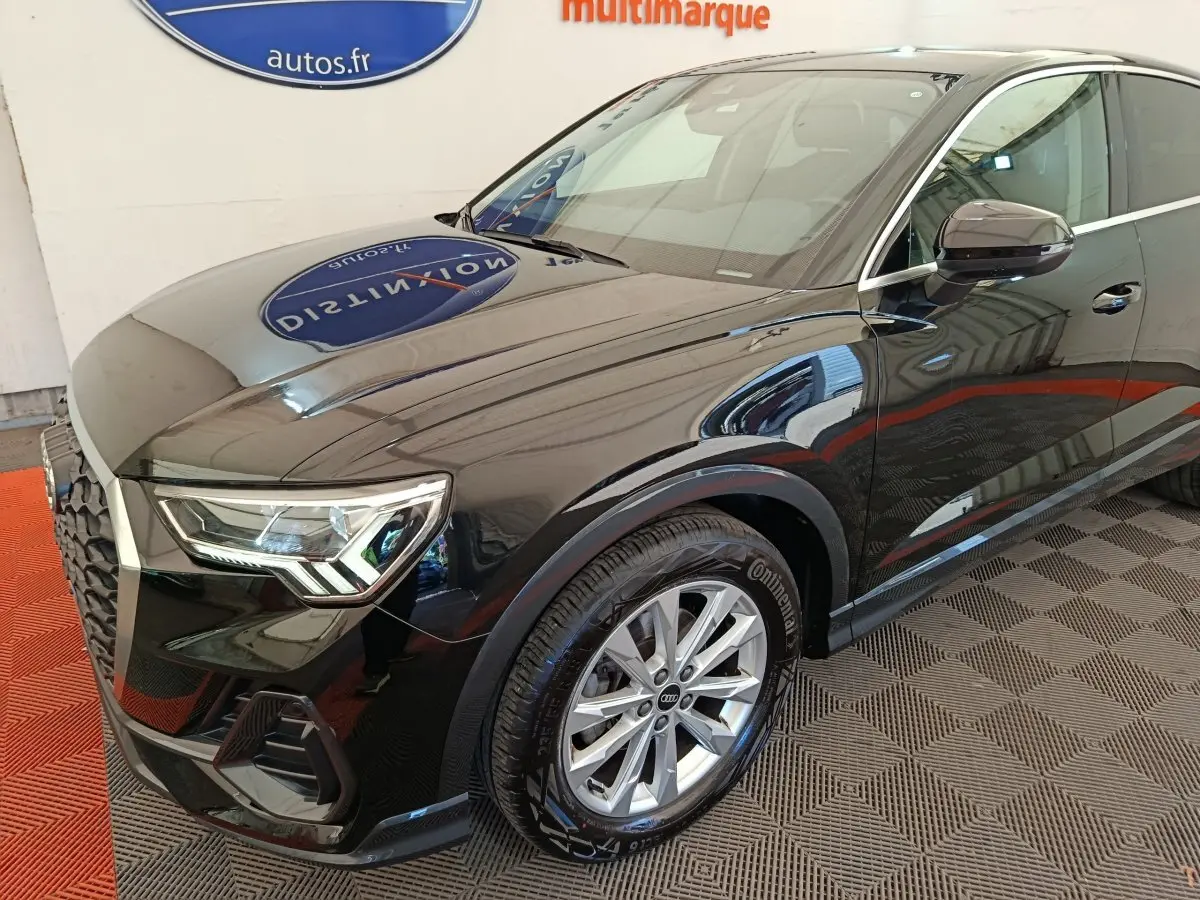 Audi Q3 Sportback noir en 3/4 avant droit, mettant en valeur ses phares LED et jantes alliage argentées.