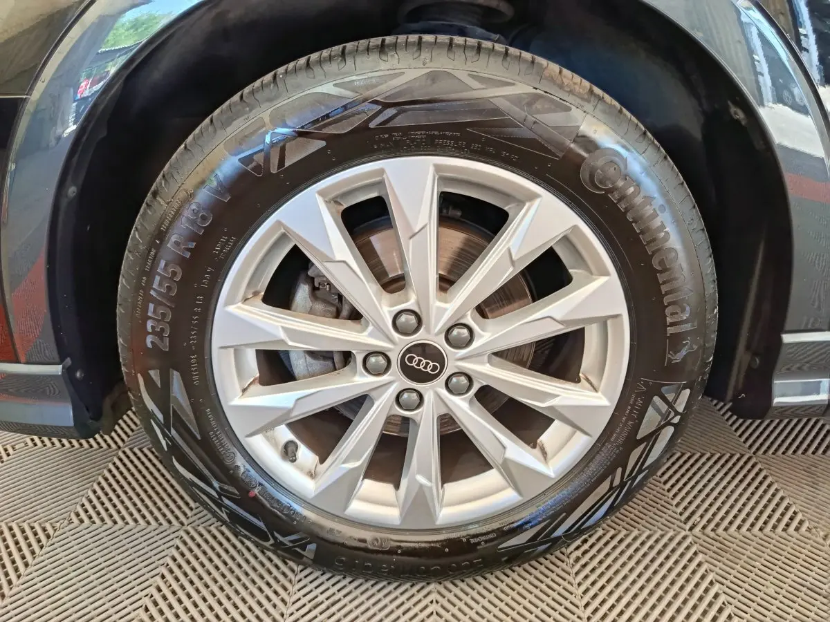 Gros plan sur la roue avant droite de l’Audi Q3 Sportback noir, avec jante alliage argentée et pneu Continental.