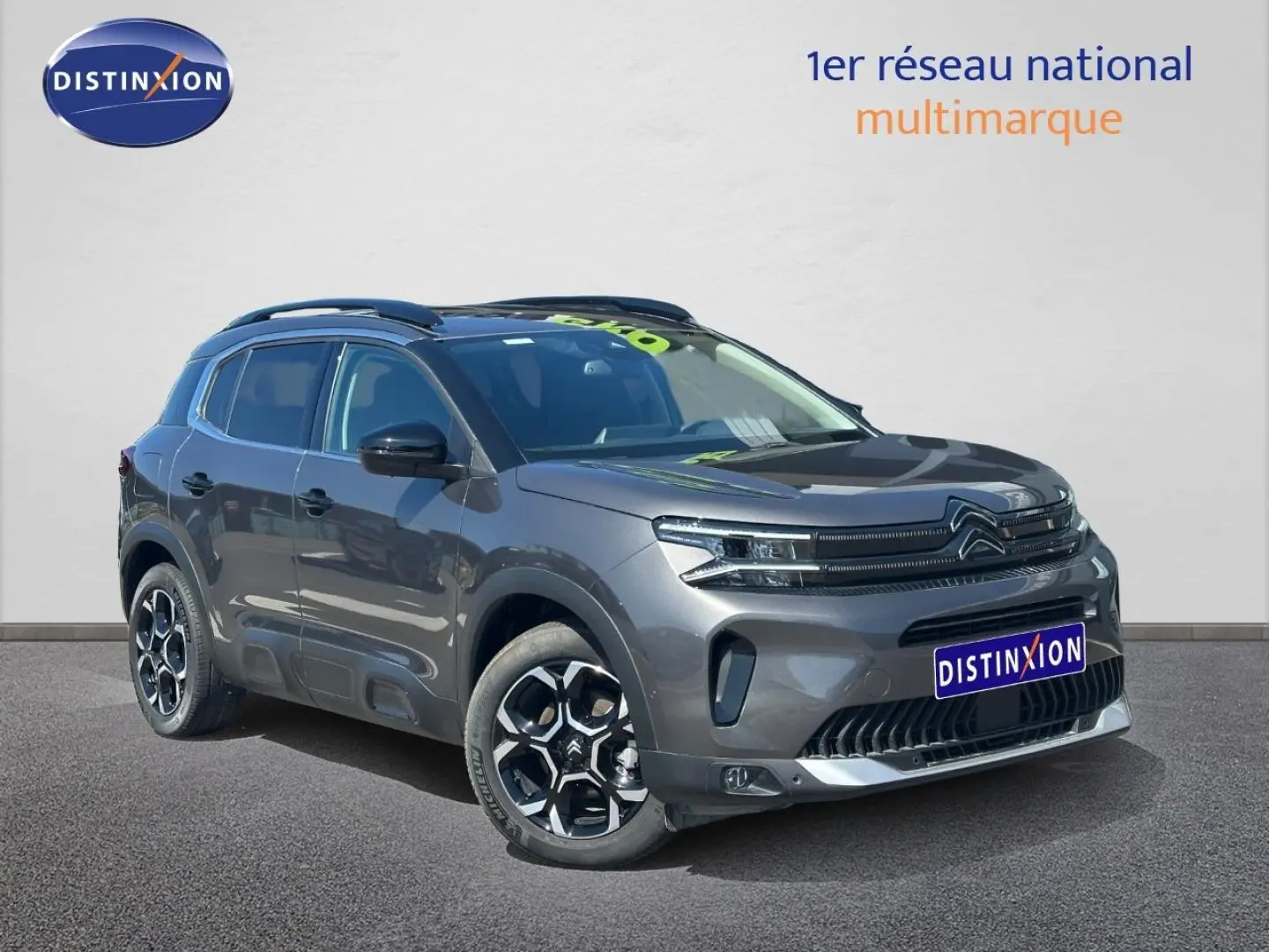 Citroën C5 Aircross gris Platinium vue 3/4 avant droit avec jantes alu et barres de toit visibles.