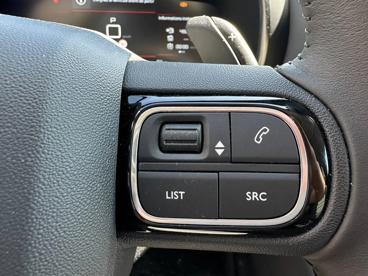 Gros plan sur les commandes noires du volant cuir du Citroën C5 Aircross 2025, finition Gris Platinium.