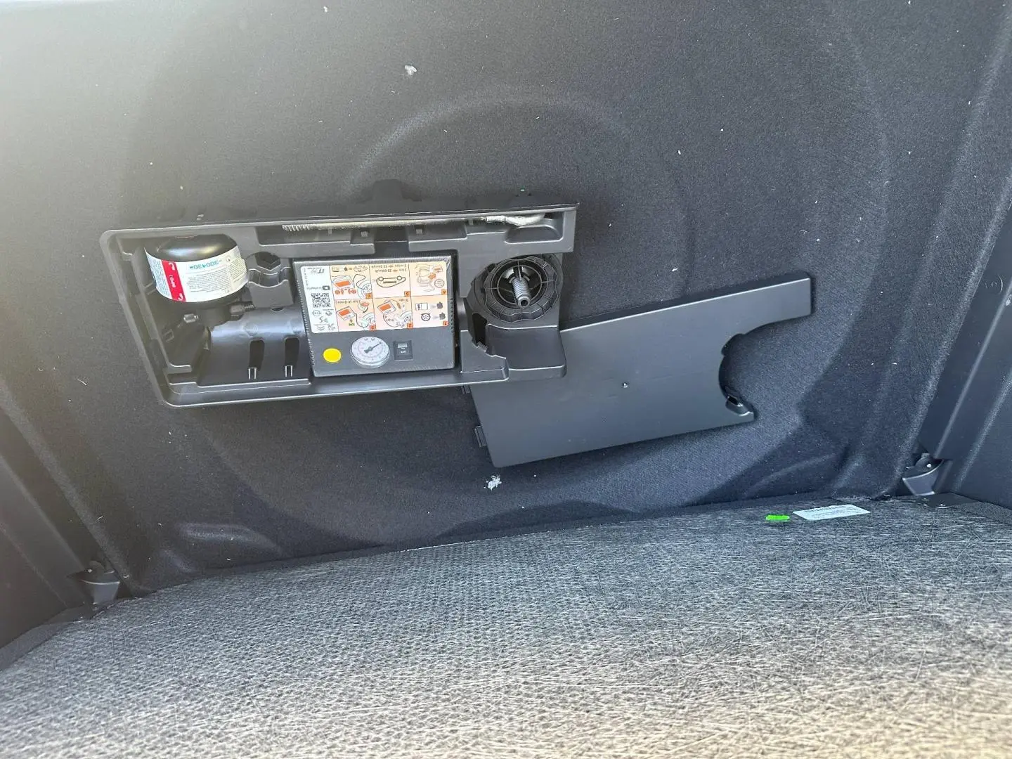 Détail du coffre du Citroën C5 Aircross gris Platinium montrant le compresseur et kit de réparation pneus intégré.