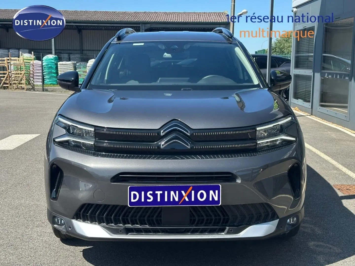 Vue frontale d'un Citroën C5 Aircross gris Platinium 2025 avec calandre distinctive et barres de toit visibles.