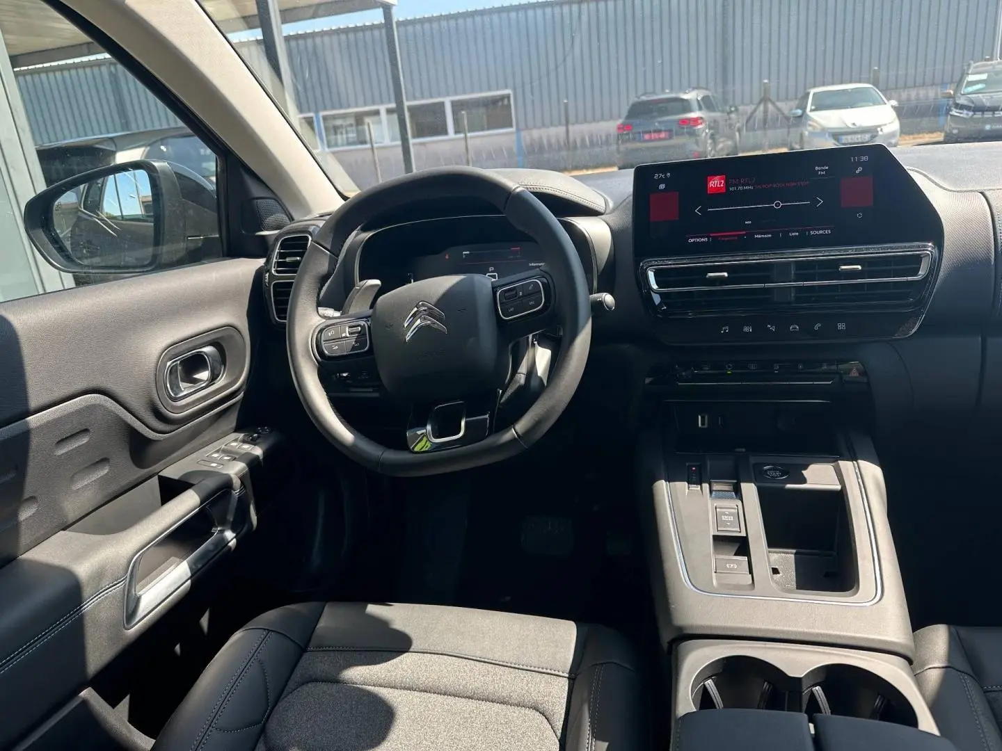 Vue intérieure avant du Citroën C5 Aircross gris Platinium, avec volant multifonction et écran tactile central.