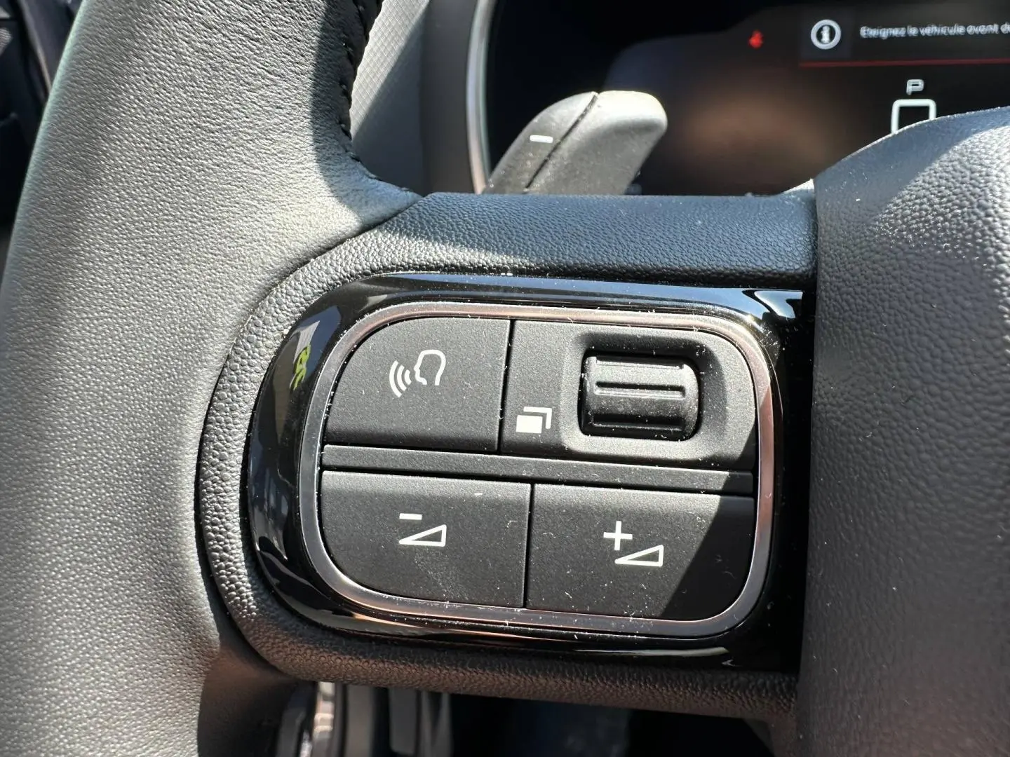 Gros plan sur les commandes multifonctions noires à gauche du volant du Citroën C5 Aircross 2025.