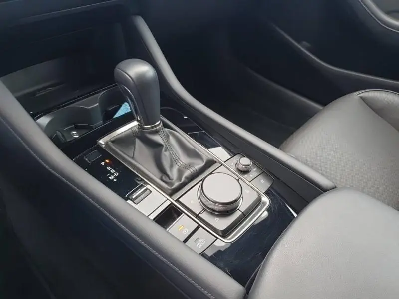 Gros plan sur la console centrale noire avec levier de vitesse automatique et commandes multimédia du Mazda3 Platinum Quartz.