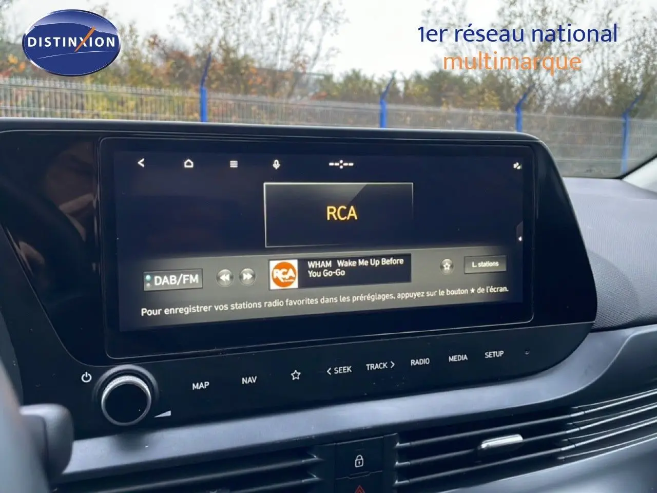 Écran tactile central du tableau de bord de la Hyundai i20 2025 affichant la radio DAB/FM en intérieur noir.
