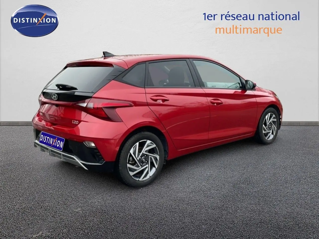 Vue 3/4 arrière droite d'une Hyundai i20 rouge Dragon Metal avec jantes alliage et vitres teintées.