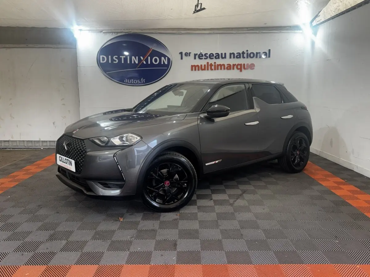 DS3 Crossback BlueHDi 110 gris foncé en 3/4 avant droit avec jantes noires et toit noir dans un showroom.