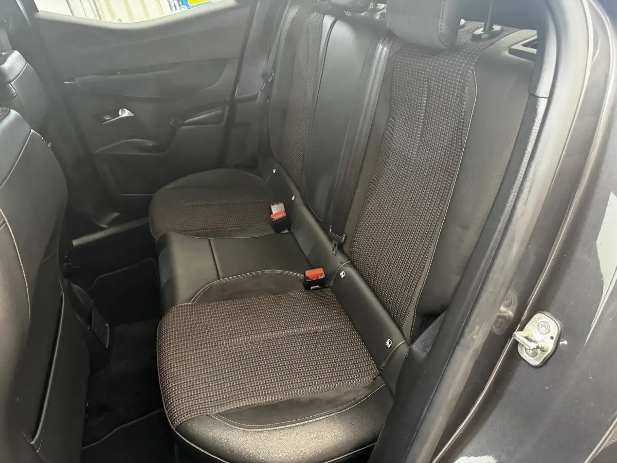 Vue côté droit de la banquette arrière en tissu et cuir noir du DS3 Crossback gris foncé, avec ceinture de sécurité visible.