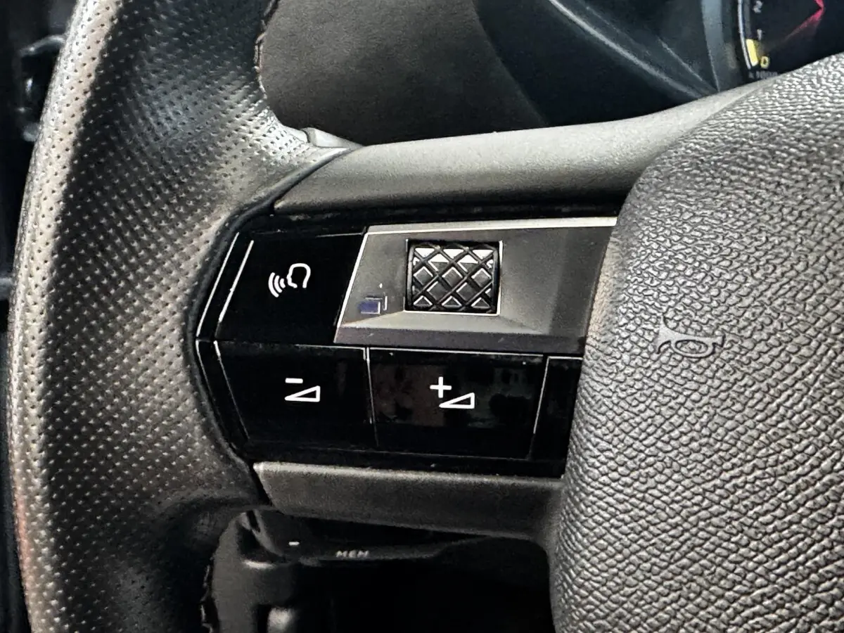 Gros plan sur le volant cuir noir perforé du DS3 Crossback 2021 avec commandes multifonctions intégrées.