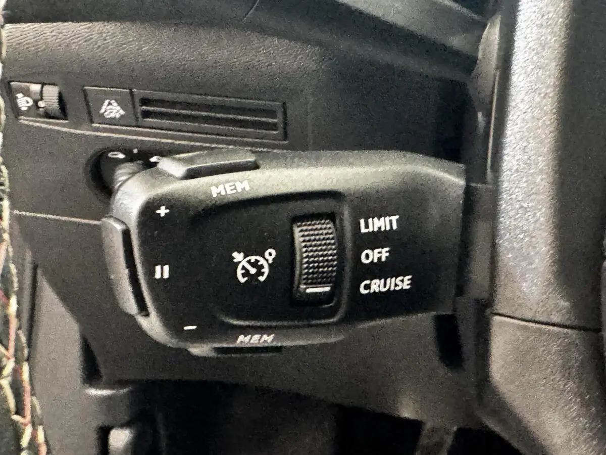 Gros plan sur la commande de régulateur de vitesse et limiteur, intérieur noir du DS3 Crossback gris foncé.