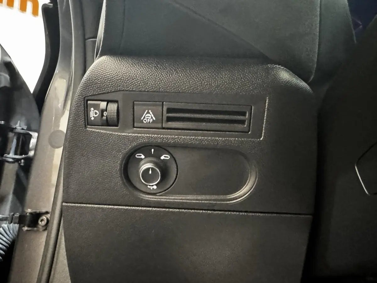Détail du tableau de bord côté gauche du DS3 Crossback gris foncé, avec commandes d'éclairage et réglage phares.