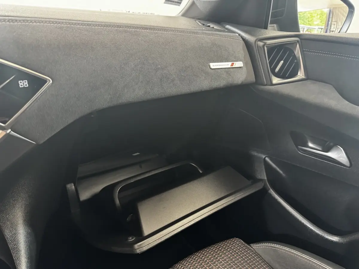 Vue intérieure côté passager du tableau de bord gris foncé avec boîte à gants ouverte du DS3 Crossback BlueHDi 110 Performance Line.