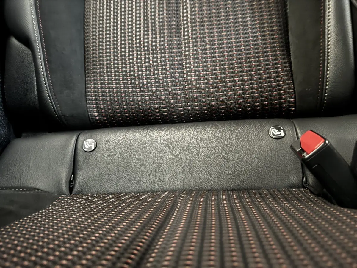 Gros plan sur la banquette arrière grise et noire du DS3 Crossback avec logos Isofix et ceinture de sécurité rouge visible.