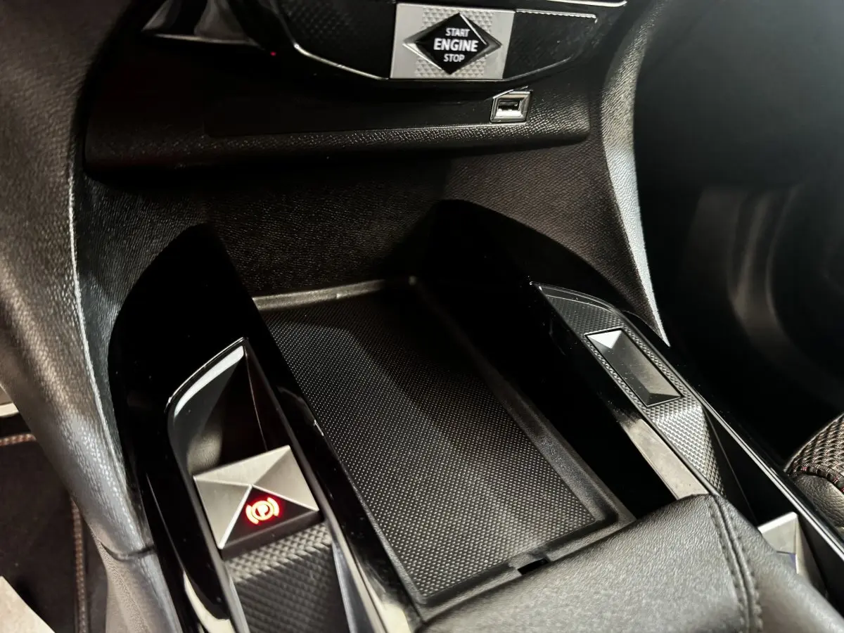 Gros plan intérieur sur la console centrale noire du DS3 Crossback 2021, avec bouton frein à main électrique et démarrage sans clé.