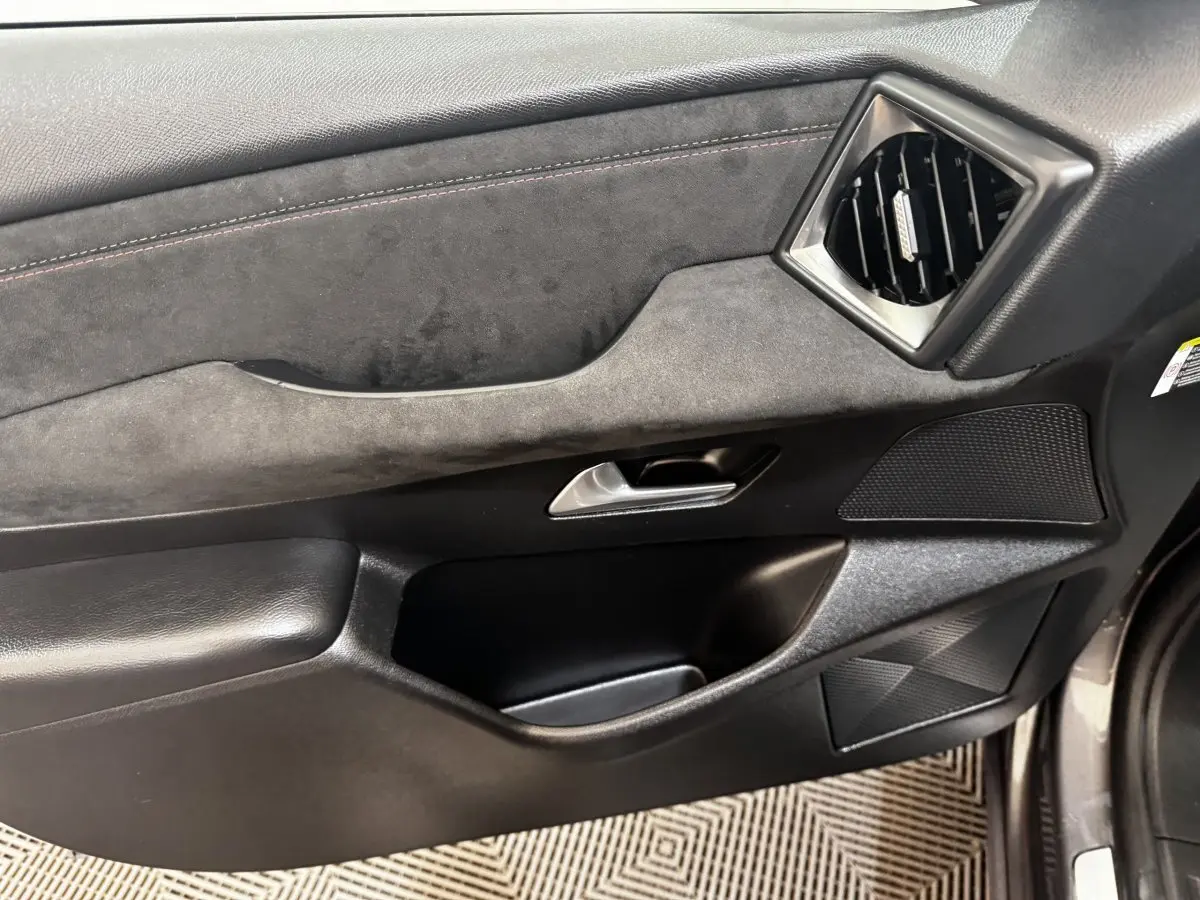 Vue intérieure du panneau de porte côté conducteur du DS3 Crossback gris foncé, avec garniture en alcantara et insert noir.