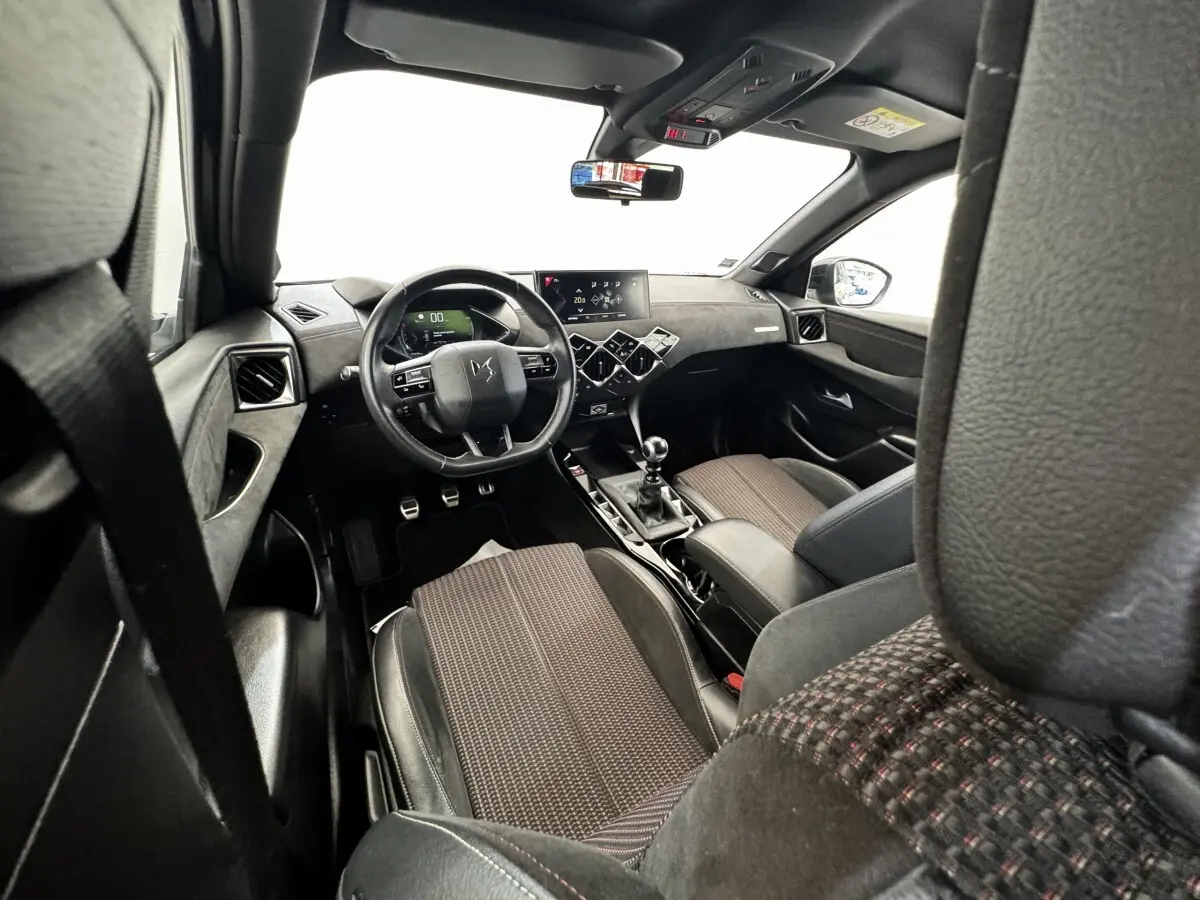 Vue intérieure avant du DS3 Crossback 2021 gris foncé, volant cuir multifonctions et écran tactile central.