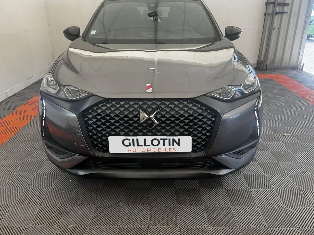 Vue avant d'une DS3 Crossback gris foncé avec calandre noire texturée et phares LED distinctifs.