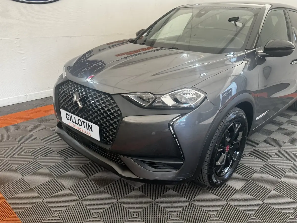 DS3 Crossback gris foncé vu en 3/4 avant droit, avec calandre noire et jantes noires brillantes.