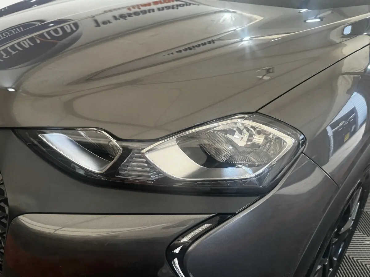 Gros plan sur le phare avant droit gris foncé du DS3 Crossback avec détails du capot et pare-chocs.
