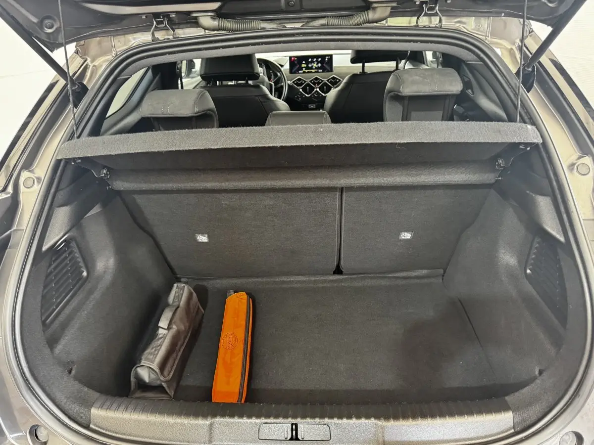 Coffre ouvert d’un DS3 Crossback gris foncé, vue arrière montrant l’espace de chargement et l’intérieur avec sièges noirs.