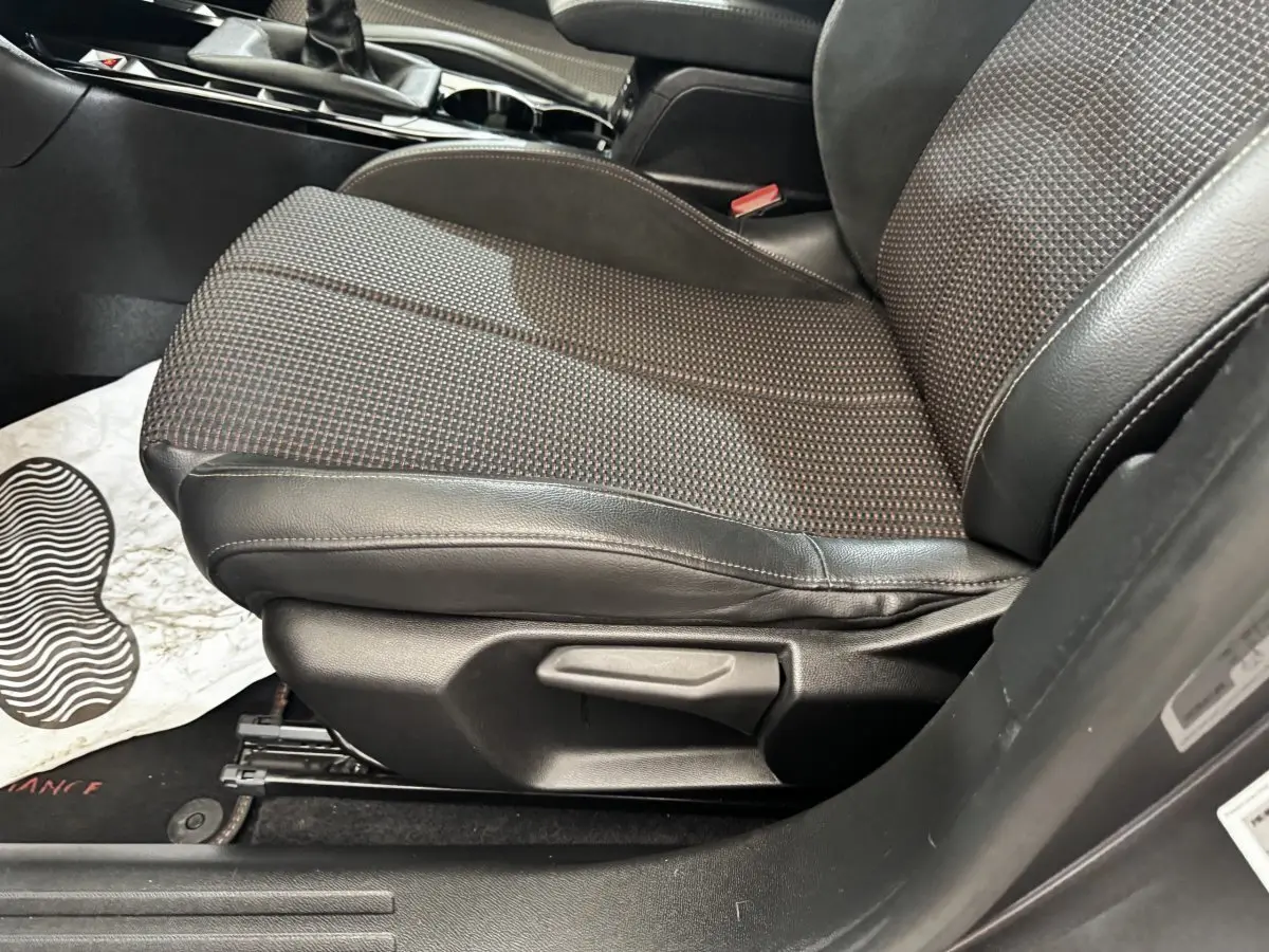 Gros plan sur le siège avant droit en tissu et cuir du DS3 Crossback gris foncé, avec levier de réglage manuel visible.