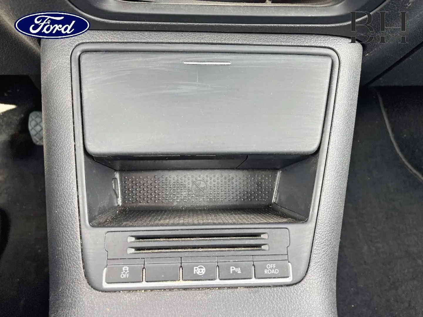 Gros plan sur la console centrale noire du Volkswagen Tiguan 2014, montrant les boutons d'aide au stationnement et mode off-road.