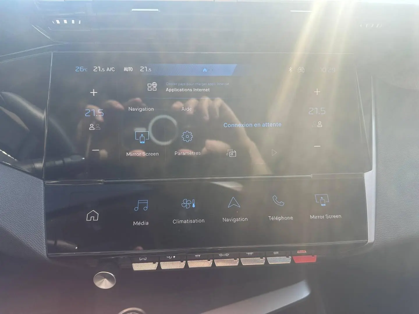 Vue rapprochée de l’écran tactile central et des commandes de la Peugeot 308 SW 1.2 Hybrid blanche, intérieur moderne.
