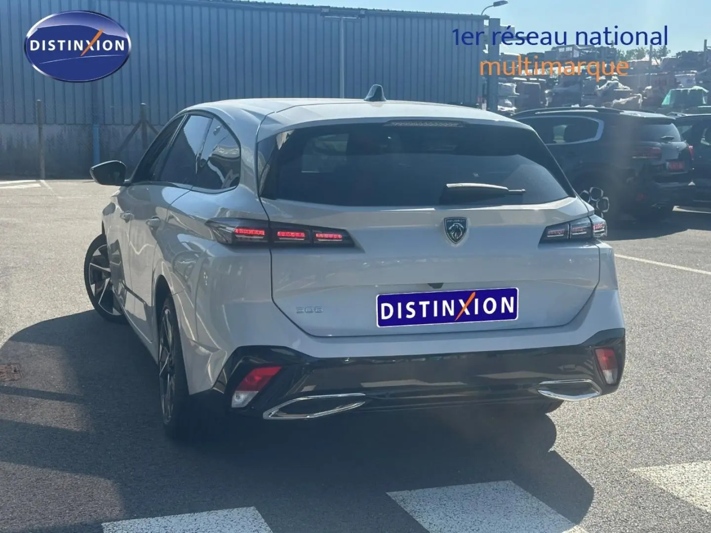 Vue 3/4 arrière d'une Peugeot 308 SW blanche Okénite avec feux arrière LED et lunette arrière surteintée.