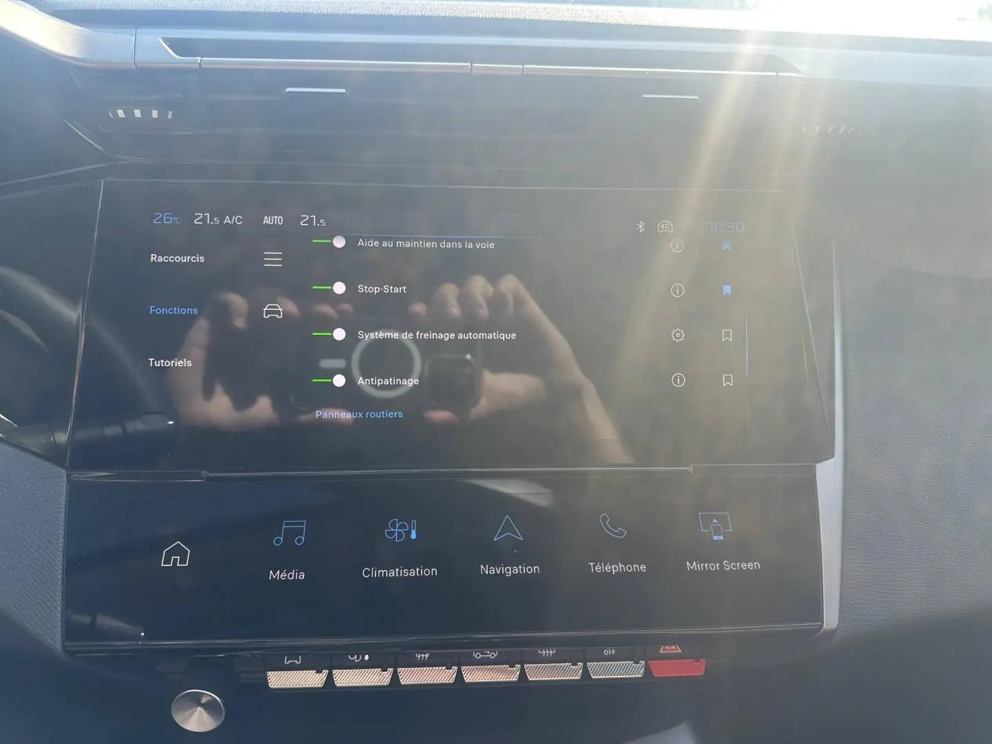 Écran tactile central avec menu des aides à la conduite dans l’habitacle d’une Peugeot 308 SW blanc Okénite.