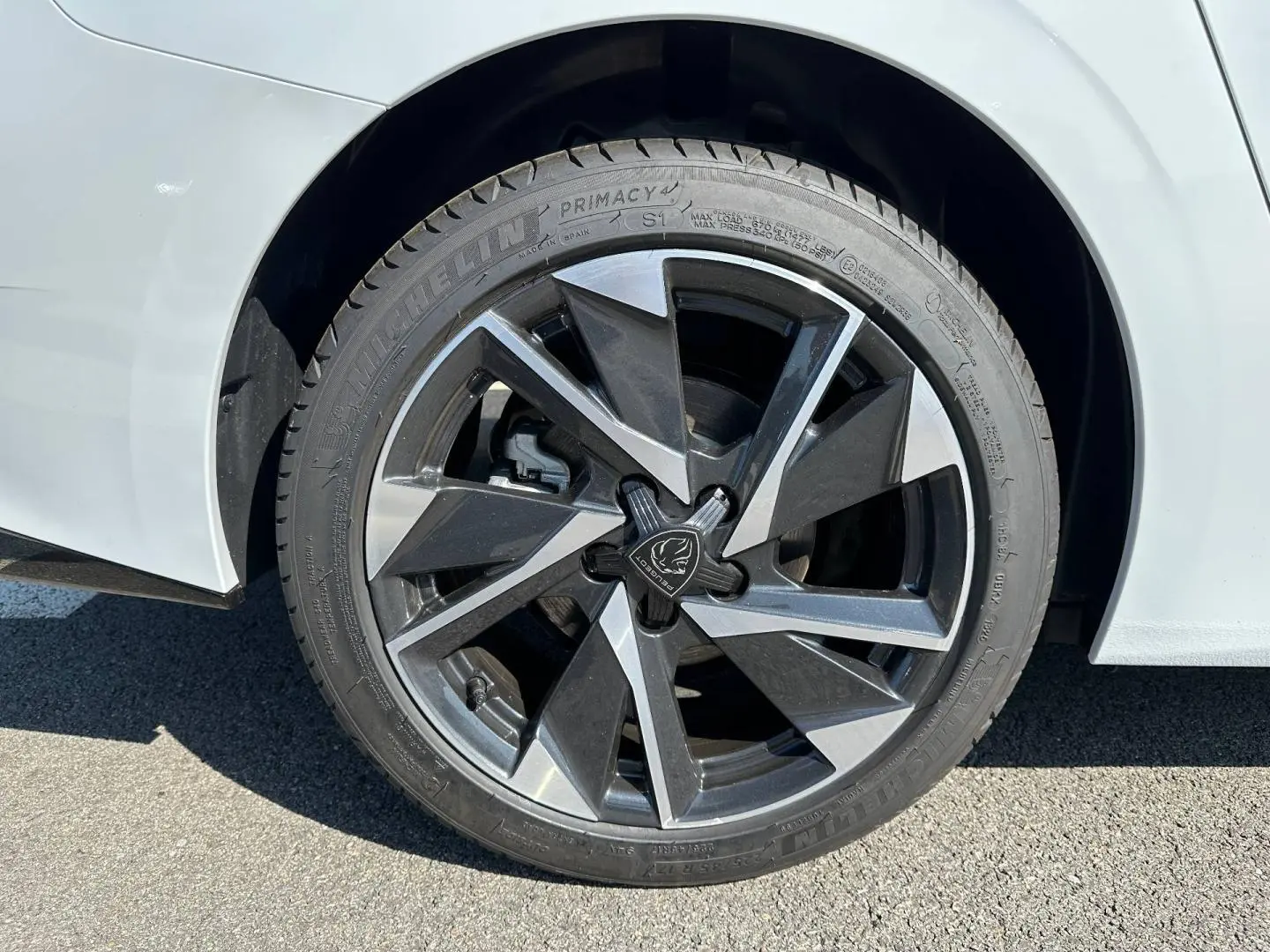 Gros plan sur la jante alu noire et argentée d'une Peugeot 308 SW blanche côté arrière droit.