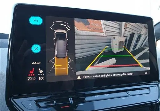 Écran de caméra de recul du Volkswagen ID.3 montrant l'arrière du véhicule blanc Glacier avec guidage de trajectoire coloré.