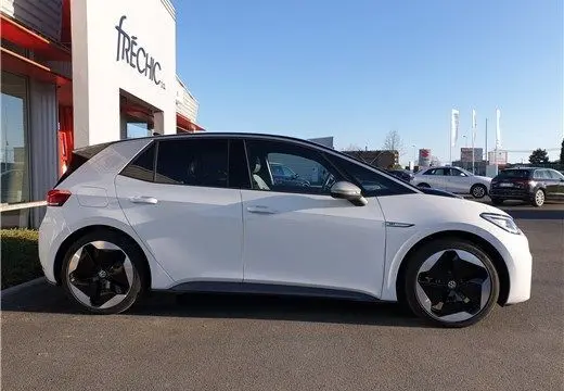 Profil droit d'une Volkswagen ID.3 blanche glacier électrique 2020 avec jantes noires distinctives sur parking.