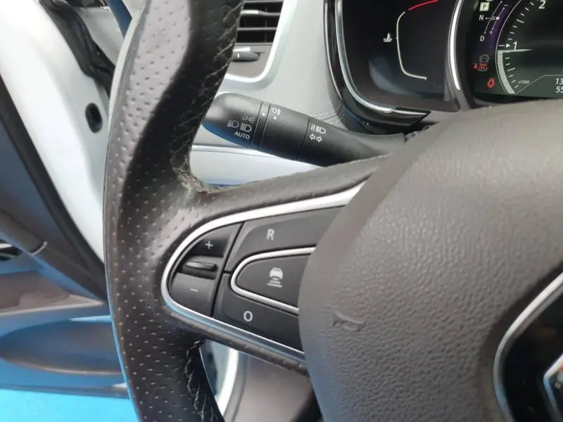 Gros plan sur le volant cuir et commandes multifonctions côté gauche du Renault Espace blanc nacré 2017.