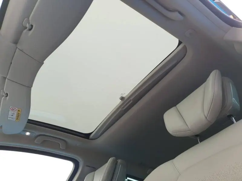 Toit ouvrant panoramique électrique vu de l'intérieur avant du Renault Espace blanc nacré avec sièges cuir beige.