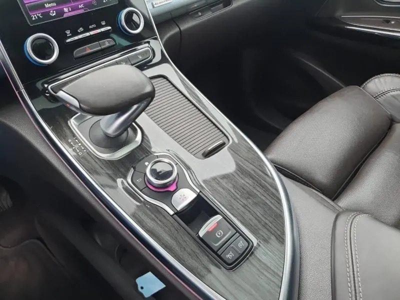 Vue rapprochée de la console centrale en bois sombre et levier de vitesse cuir du Renault Espace blanc nacré 2017.